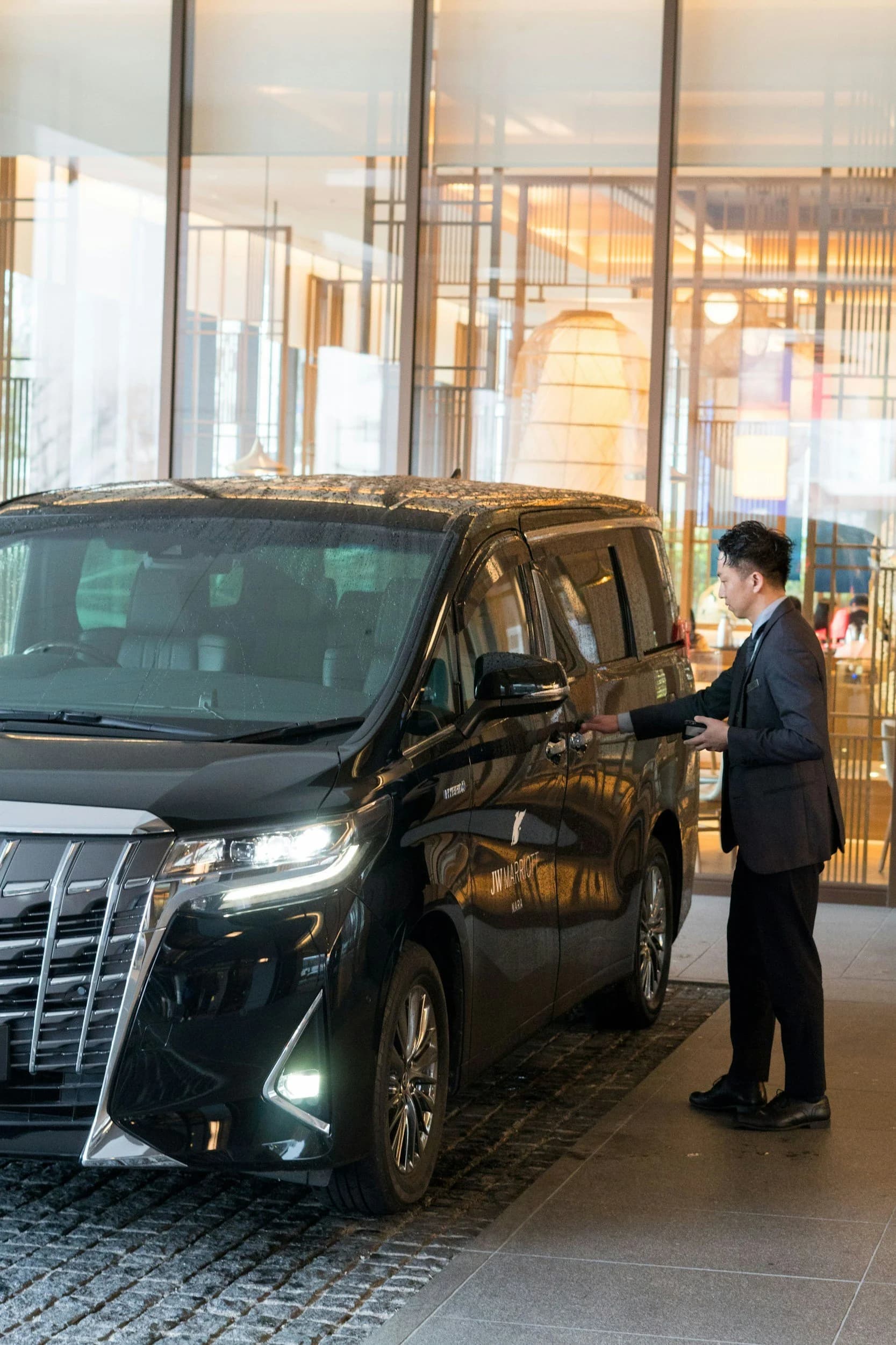Chauffeur opening the door of a luxury sedan